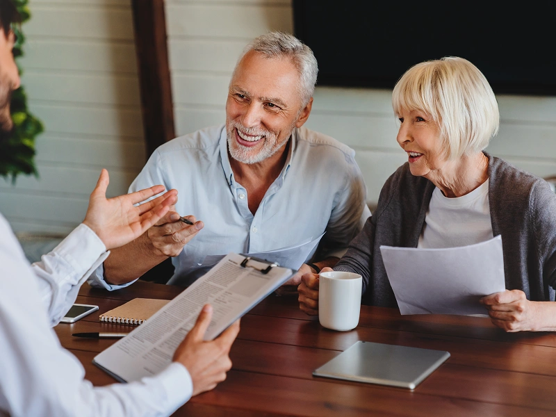 Elderly couple smiling during a meeting.