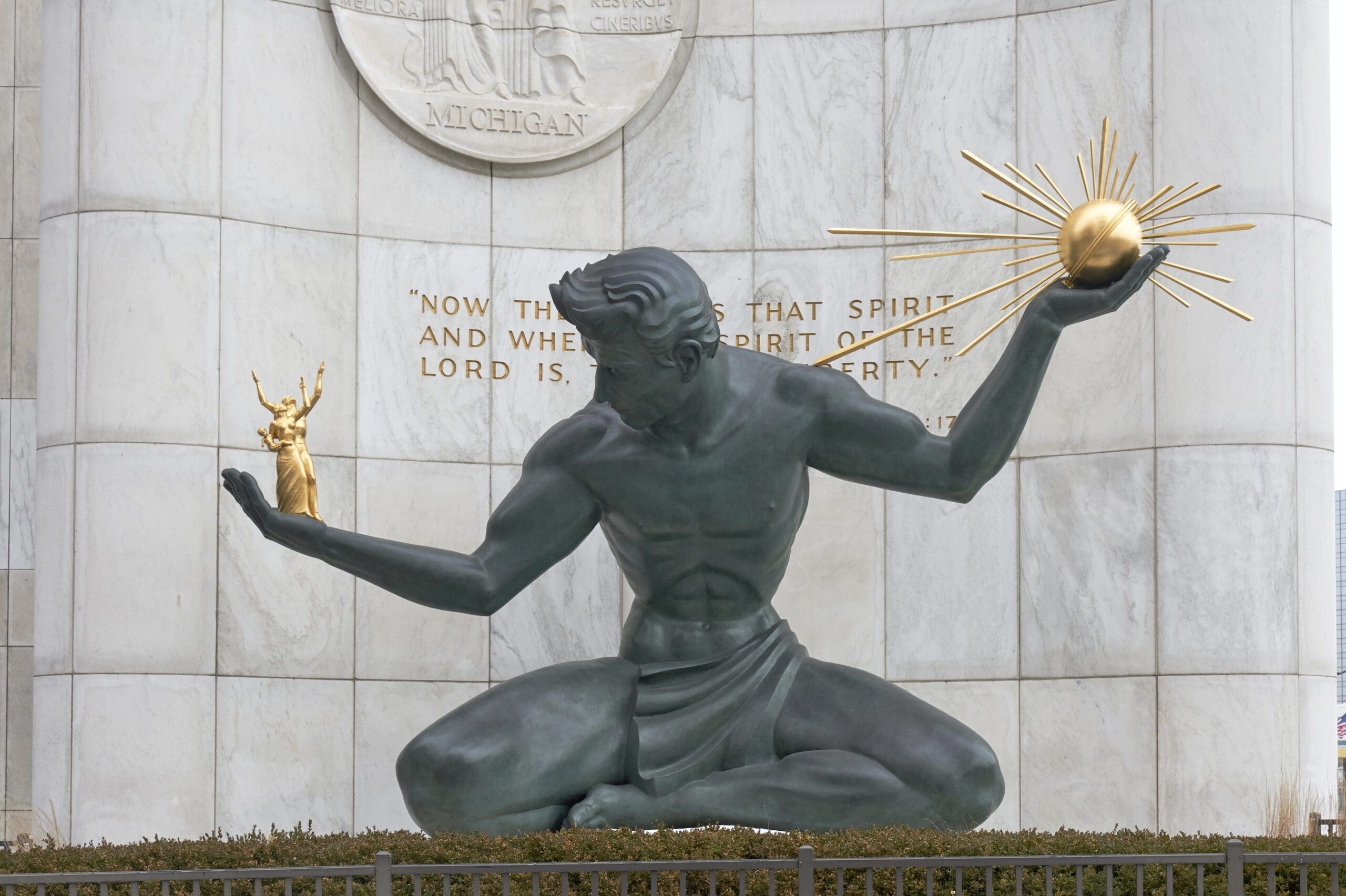 The Spirit of Detroit statue holding a golden orb and a figure.