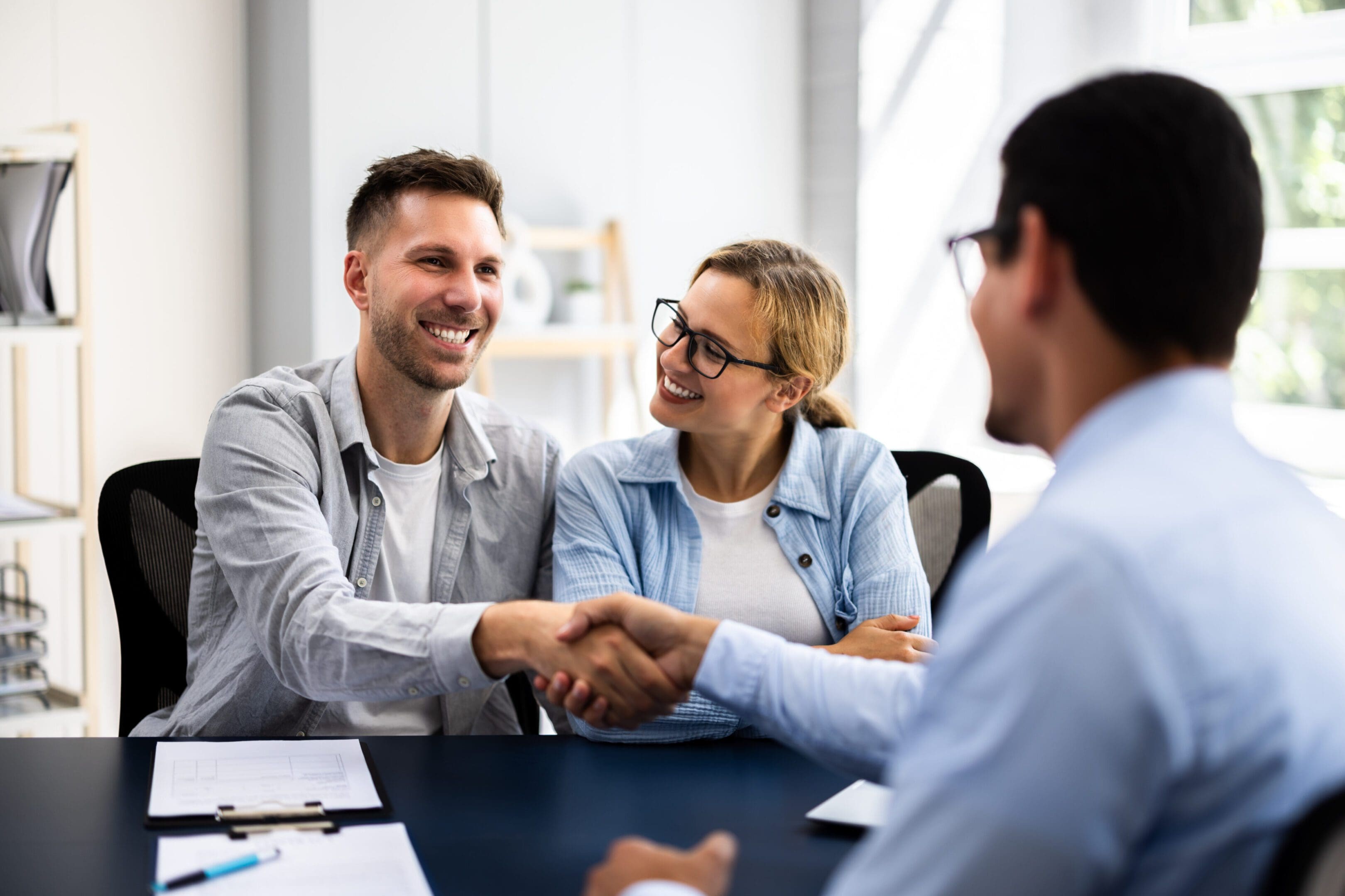 Two professionals shaking hands during a business meeting.